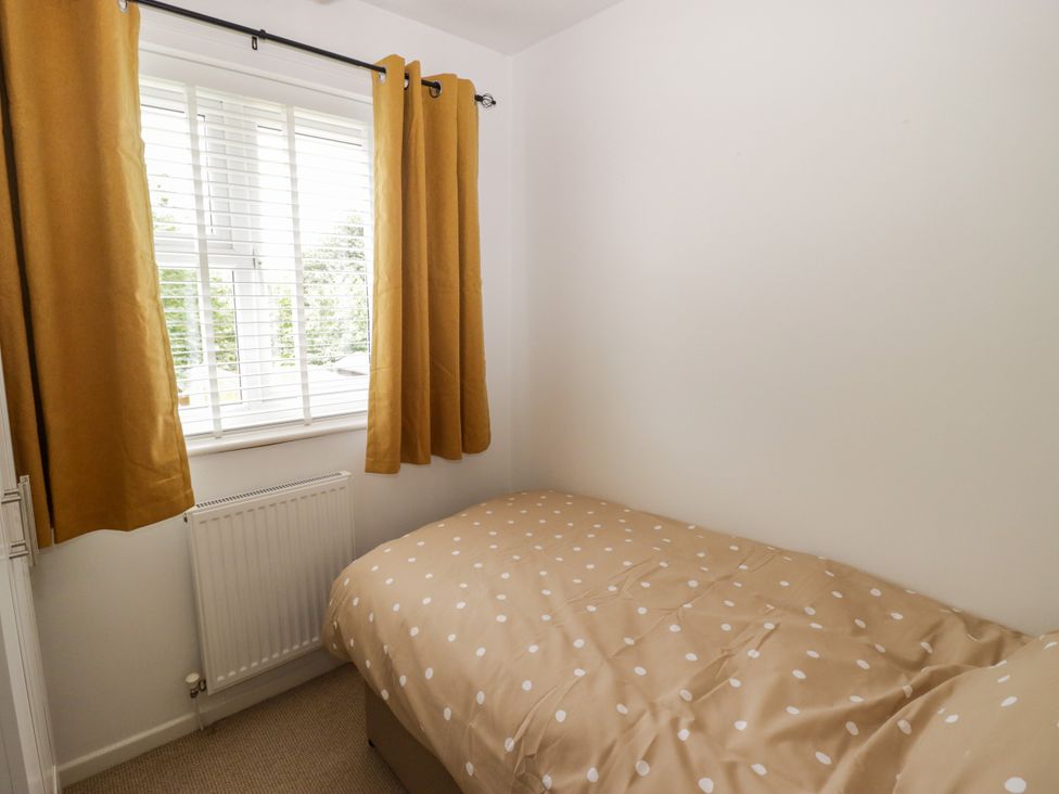 A bedroom with a bed and curtains at 7 Cwrt Y Cadno in Llantwit Major