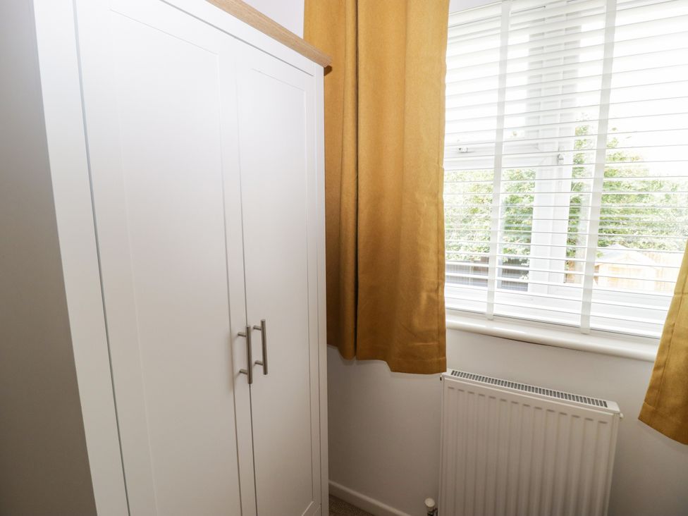 A bedroom with a wardrobe and window at 7 Cwrt Y Cadno Llantwit Major