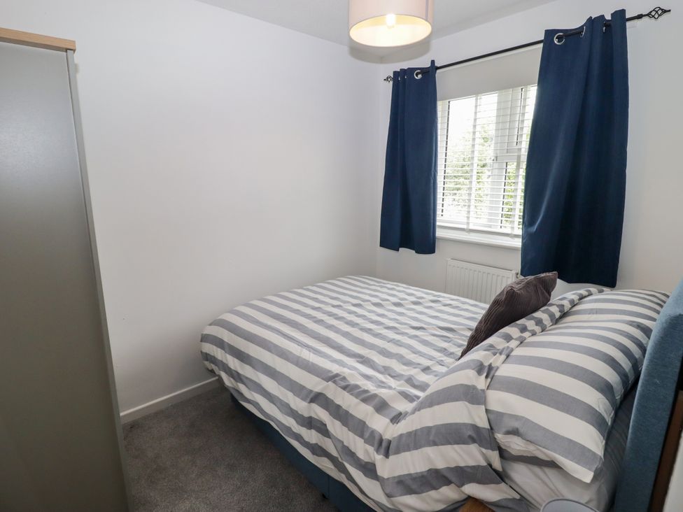 A bedroom with a bed and curtains at 7 Cwrt Y Cadno in Llantwit Major