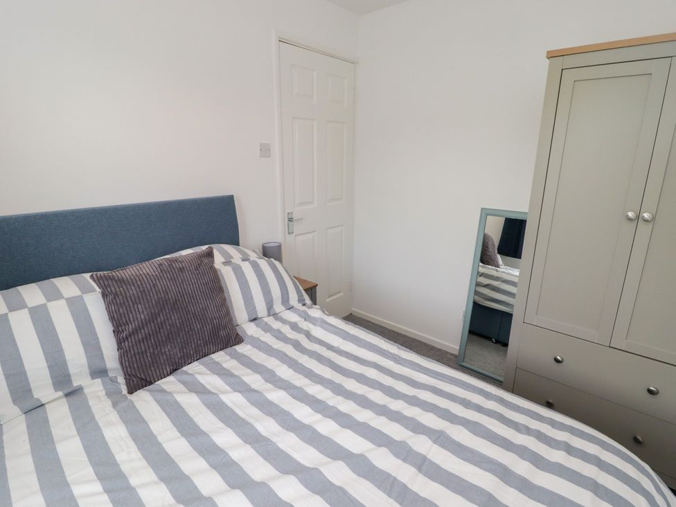 A bedroom with a bed and wardrobe at 7 Cwrt Y Cadno in Llantwit Major