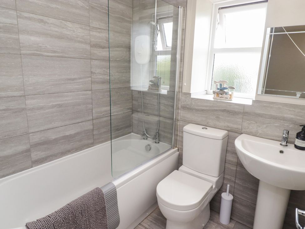 A bathroom with a bathtub, shower, toilet, and sink at 7 Cwrt Y Cadno in Llantwit Major