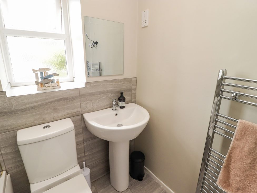 A bathroom with a toilet and sink at 7 Cwrt Y Cadno in Llantwit Major