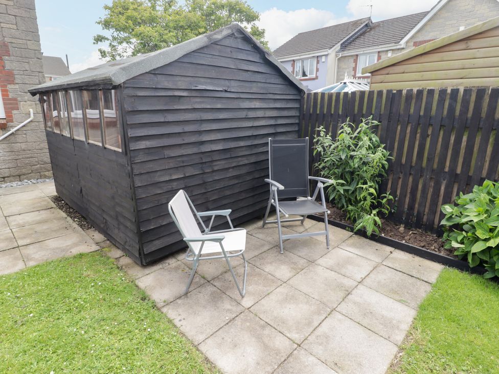 A garden with a shed and two seating chairs at 7 Cwrt Y Cadno Llantwit Major