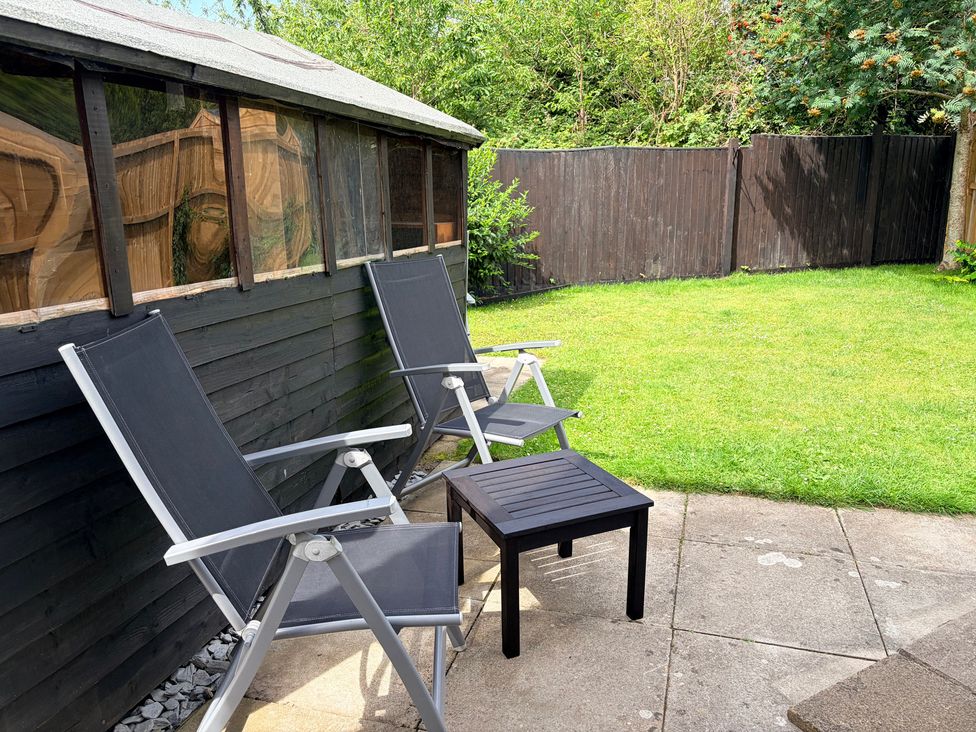 A garden with chairs and a table at 7 Cwrt Y Cadno in Llantwit Major