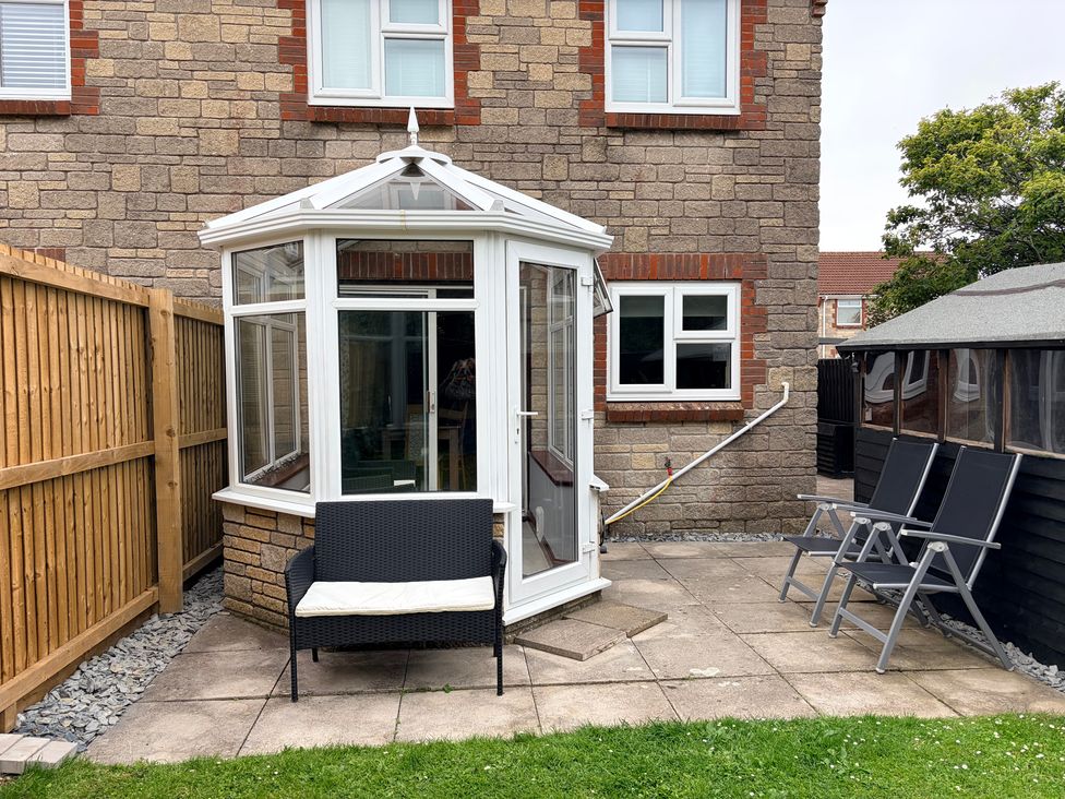 A conservatory with seating adjacent to a garden at 7 Cwrt Y Cadno Llantwit Major