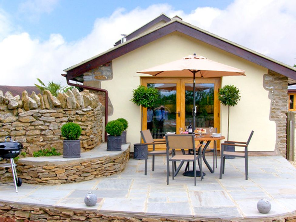An outdoor dining area with table and chairs at Howle Hideaway in Ross-on-Wye