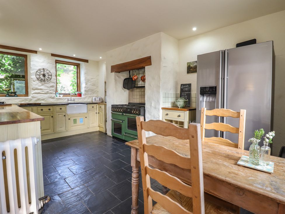 A kitchen with a refrigerator and cooking range at Pandy Farmhouse