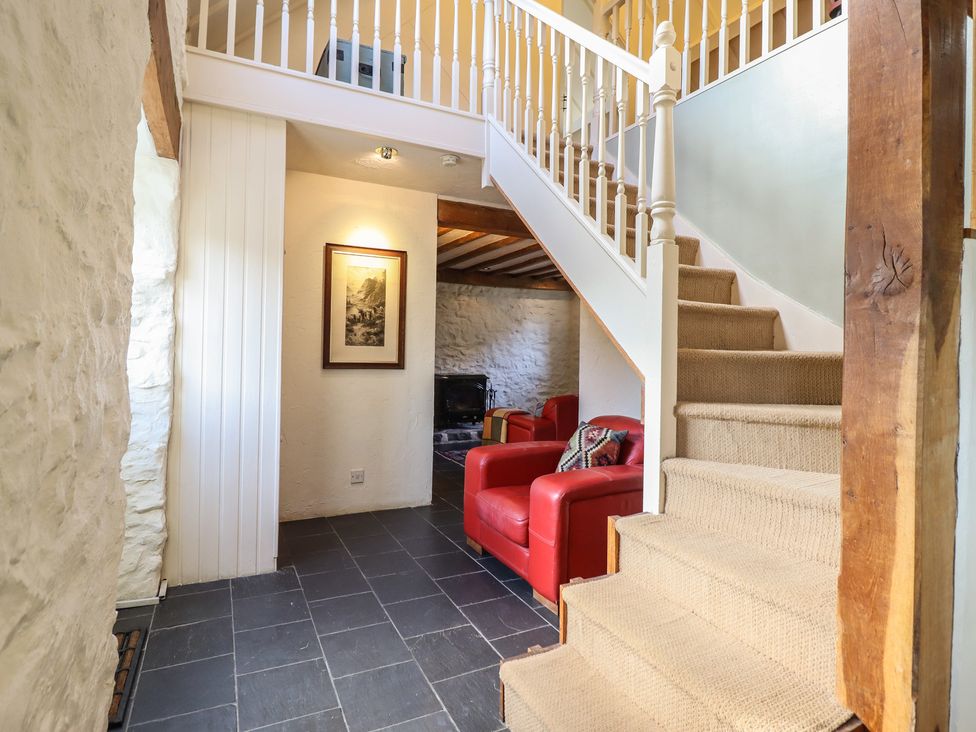 A hallway with stairs and seating at Pandy Farmhouse in 