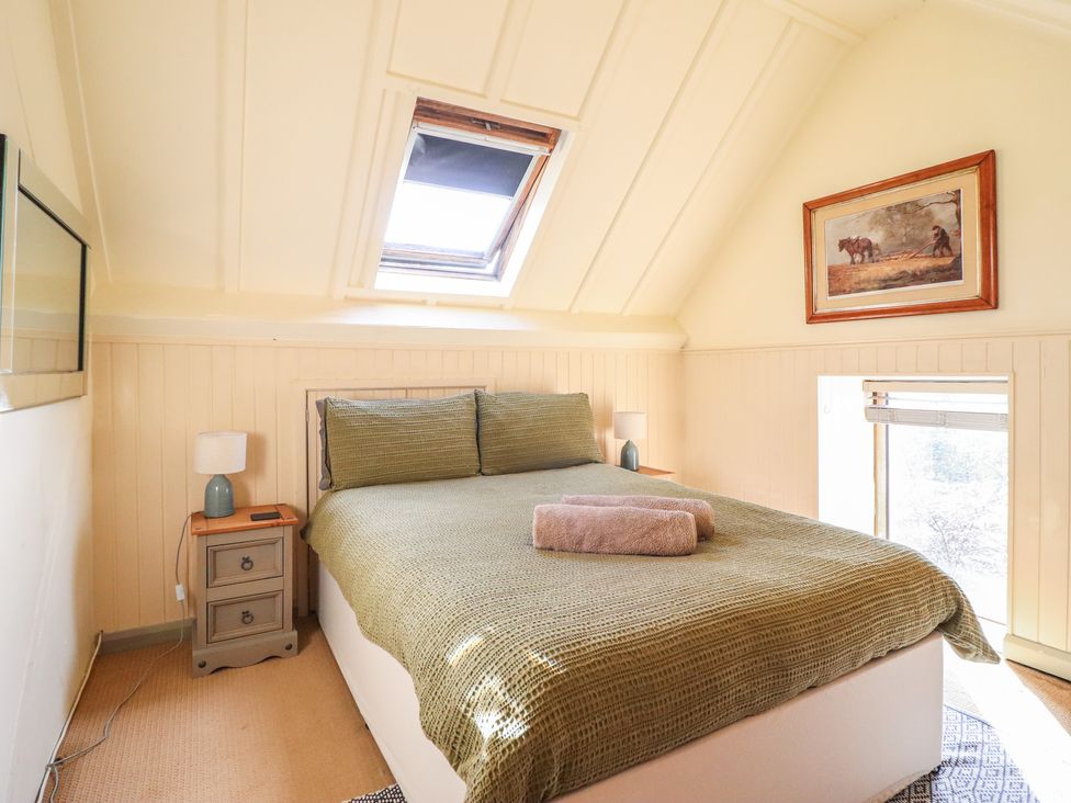 A bedroom with a bed and window at Pandy Farmhouse