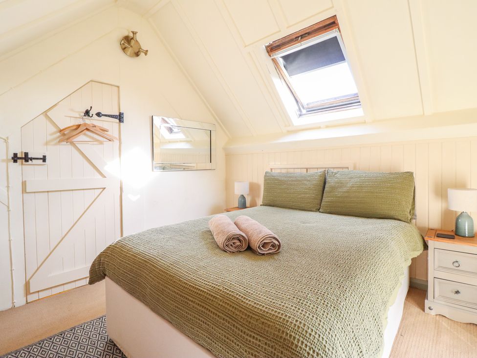 A bedroom with a bed and towels at Pandy Farmhouse