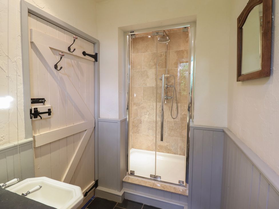 A bathroom with a shower and bathtub at Pandy Farmhouse
