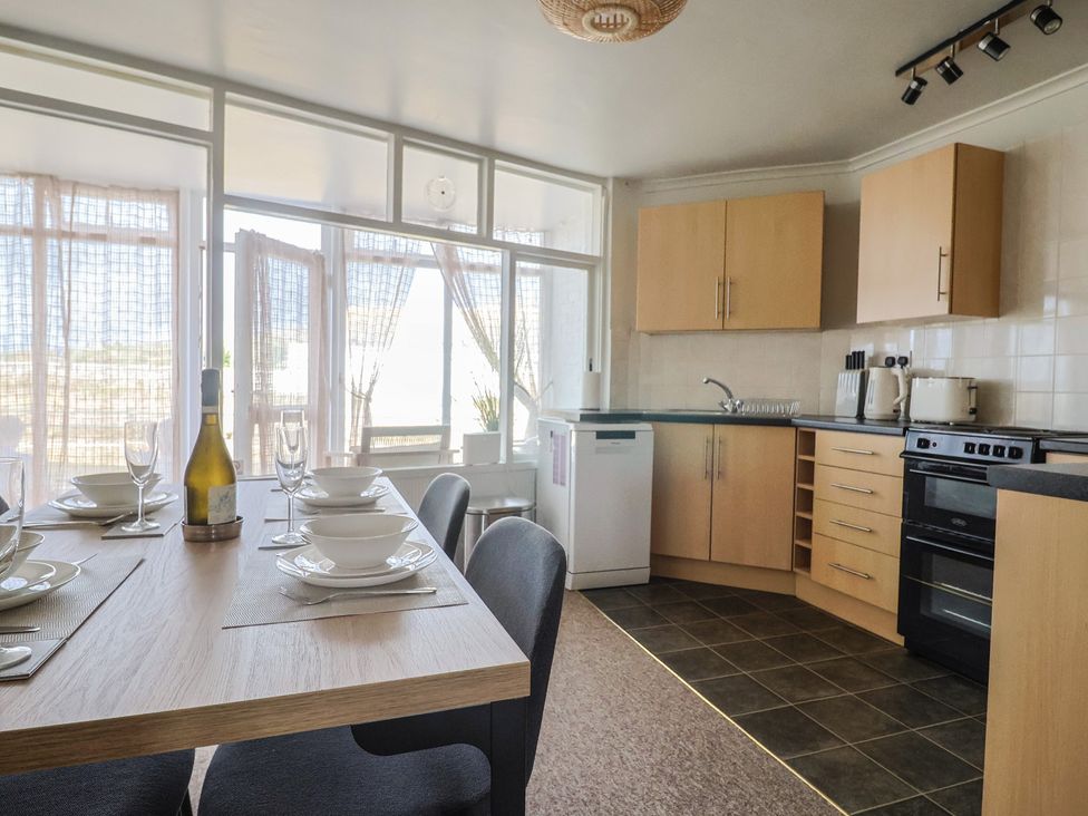 A kitchen with a dining table and dining ware at 4 Kingfisher Court West Bay
