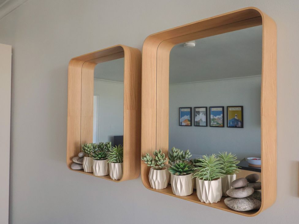 A wall with mirrors and decorative plants at 4 Kingfisher Court in West Bay