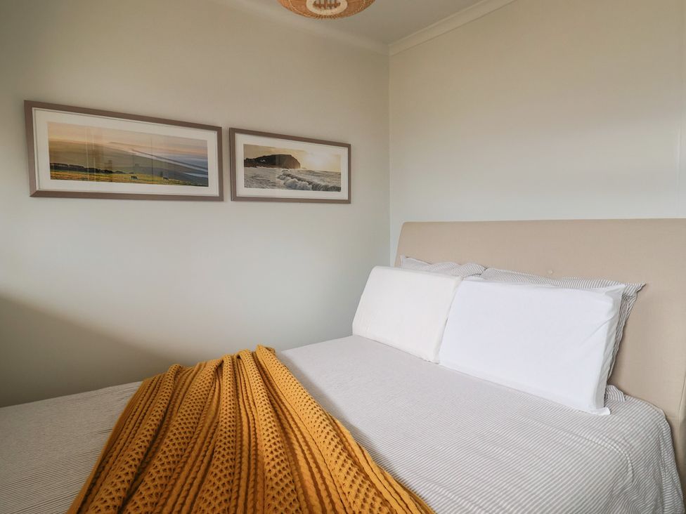 A bedroom with a bed and wall art at 4 Kingfisher Court in West Bay