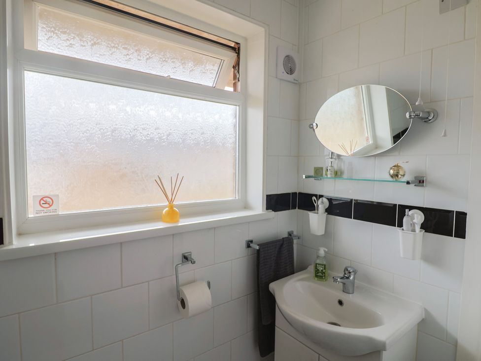 A bathroom with sink and mirror at 4 Kingfisher Court West Bay