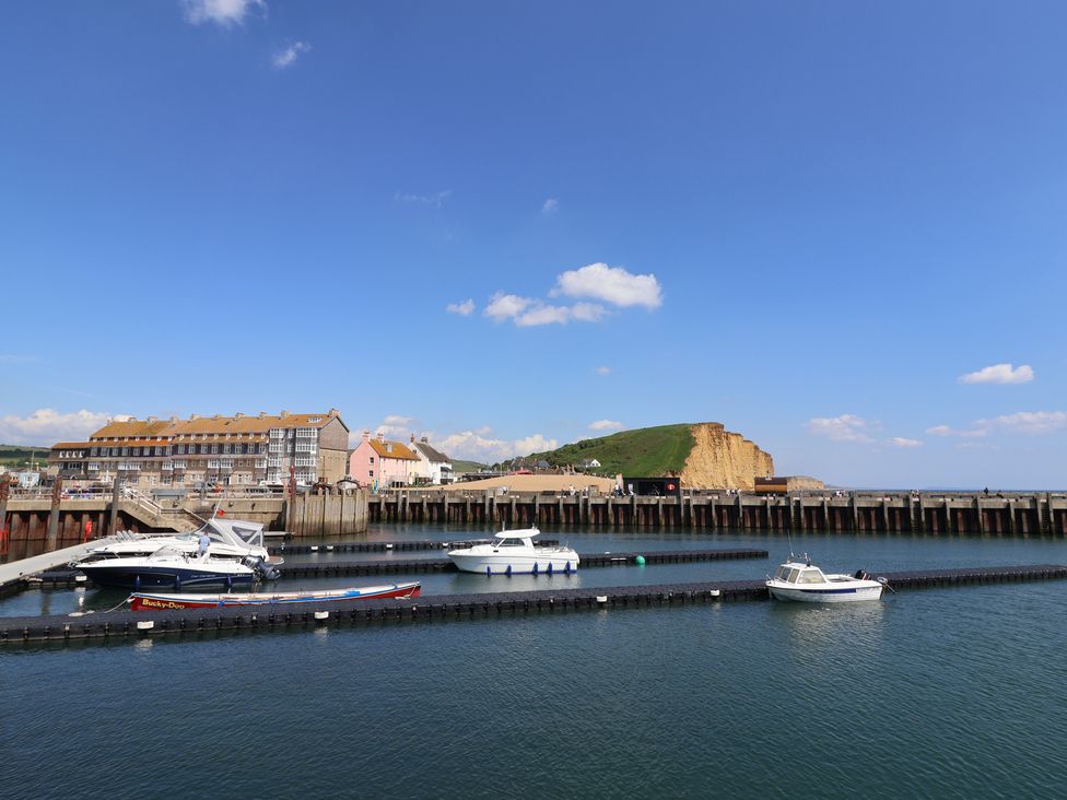 A waterfront scene with boats and buildings at 4 Kingfisher Court in West Bay