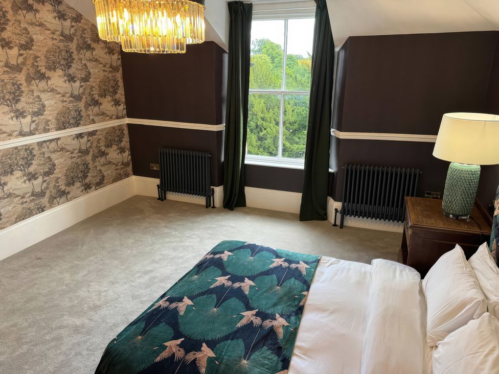 A bedroom with a bed and window at The Buxton Suite in Buxton