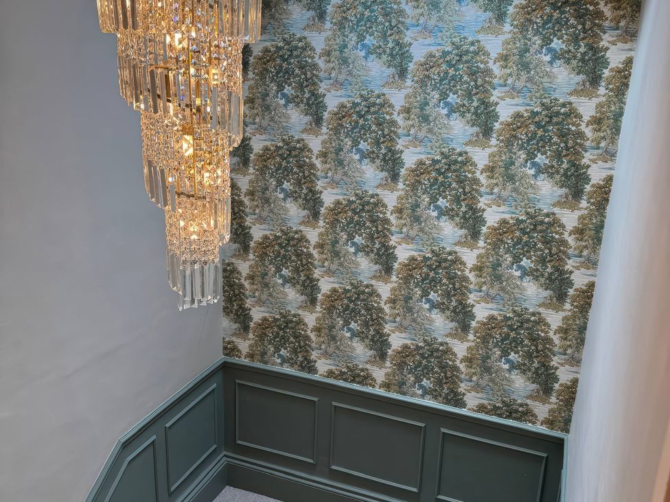 A chandelier and wallpaper in a hallway at The Buxton Suite in Buxton
