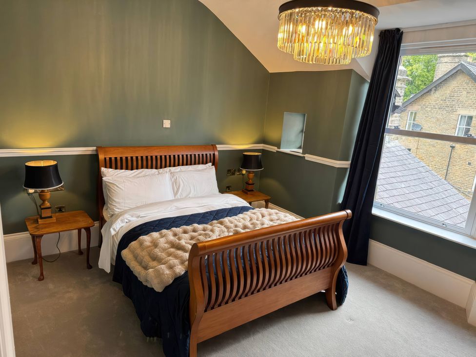A bedroom with a bed and bedside table at The Buxton Suite in Buxton