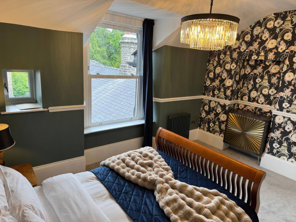 A bedroom with a bed and window at The Buxton Suite in Buxton