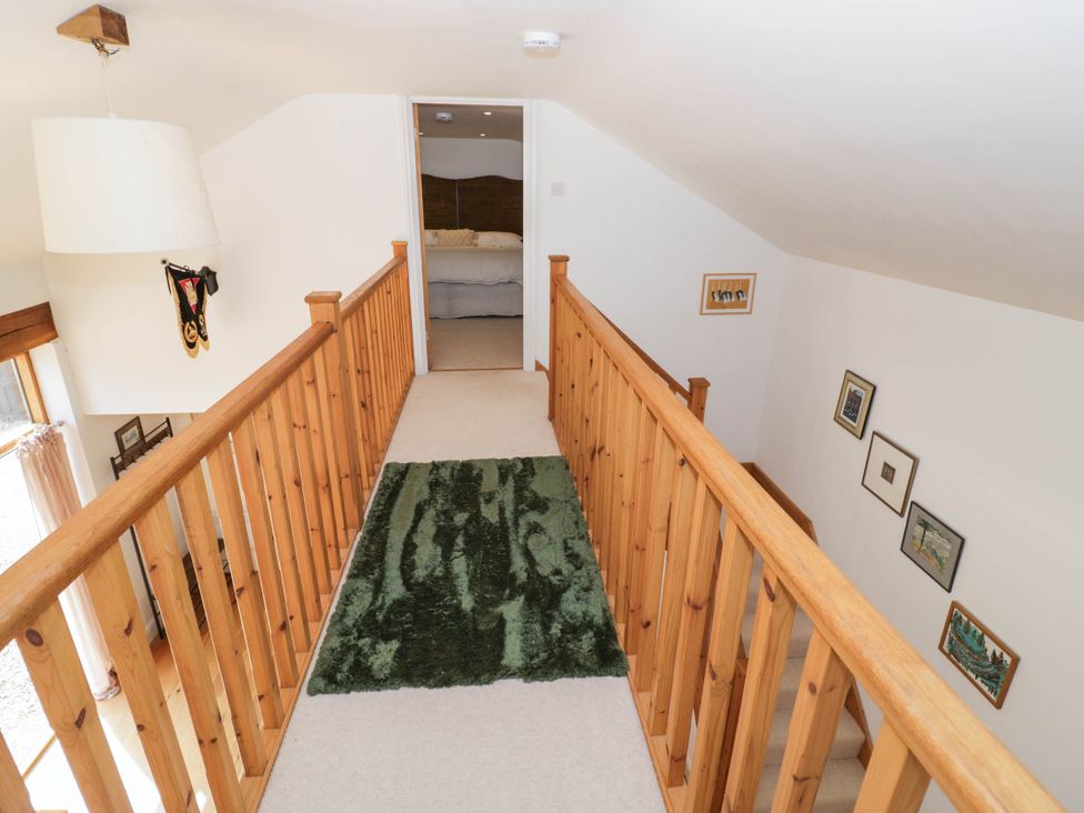 A landing with a wooden banister and a rug at Wayside in Moreton-in-Marsh