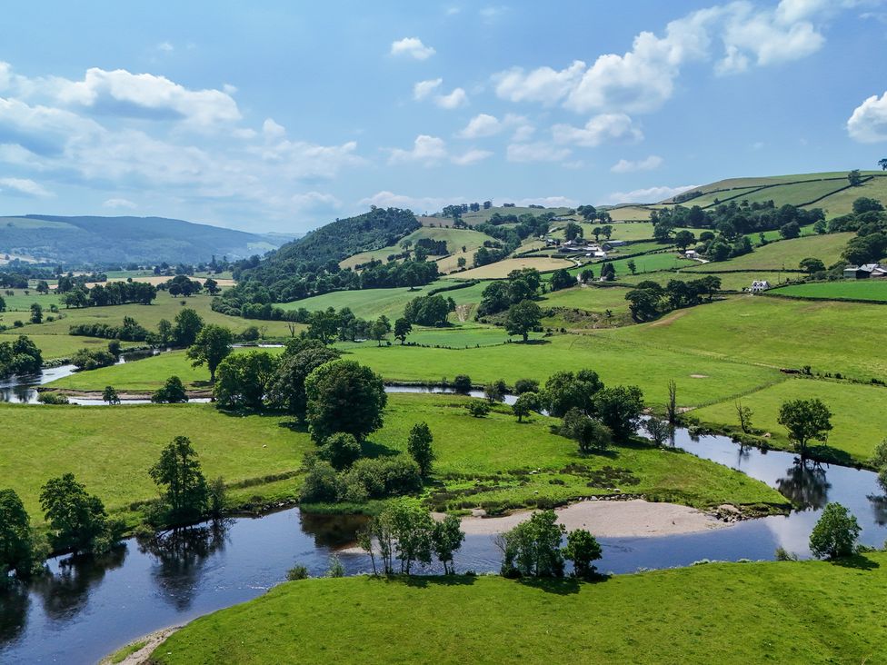A landscape with a river and fields at The Granary in Corwen