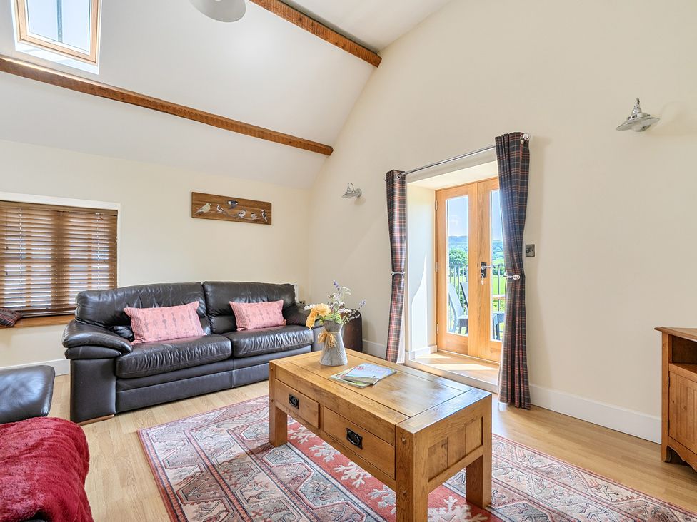 A living room with a sofa and table at The Granary in Corwen