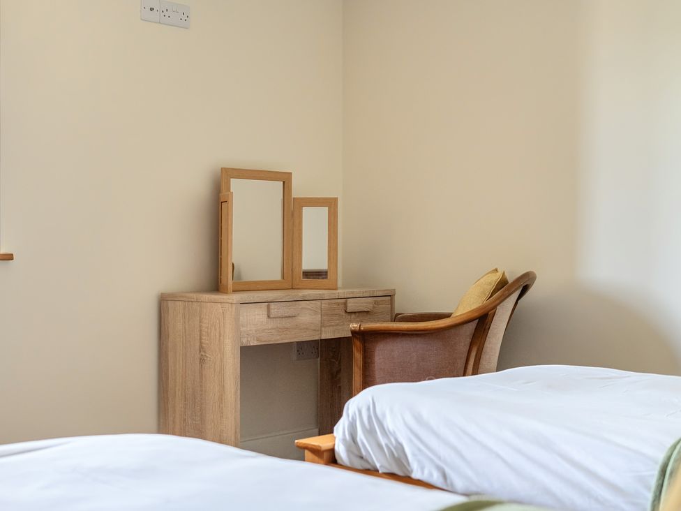 A bedroom with a dressing table and mirrors at The Granary in Corwen