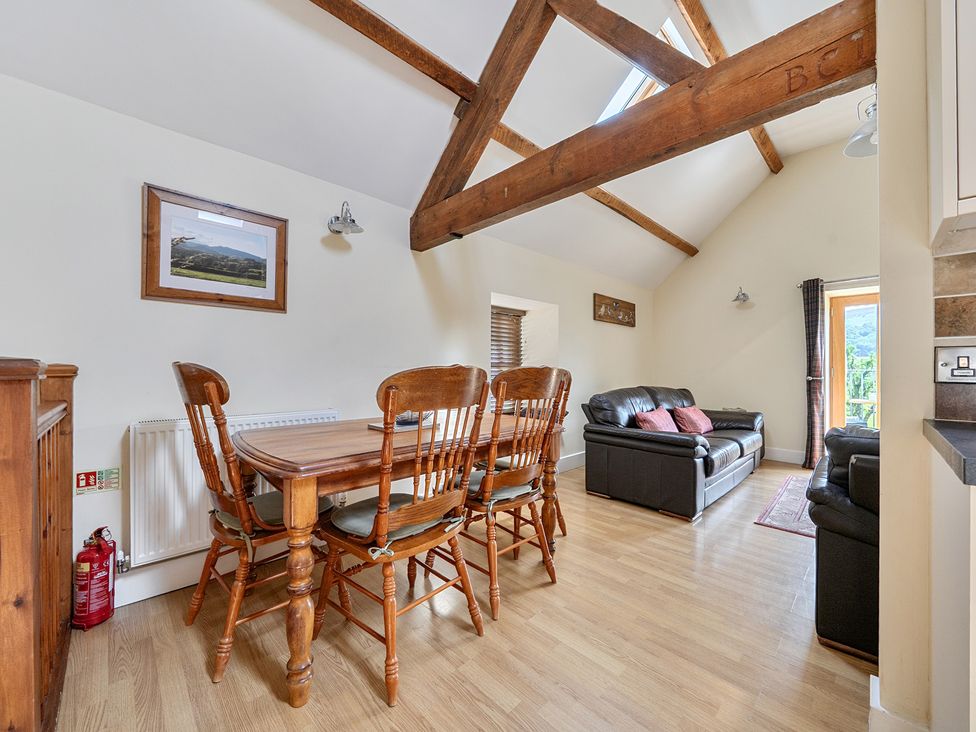A living room and dining area with a table and chairs at The Granary in Corwen