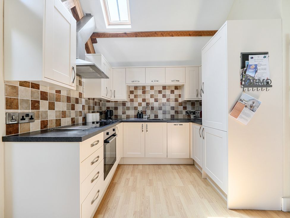 A kitchen with cabinets and appliances at The Granary in Corwen