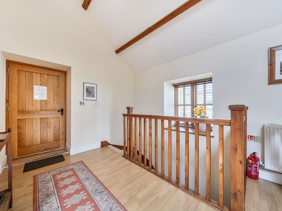 A hallway with a door and window at The Granary in Corwen