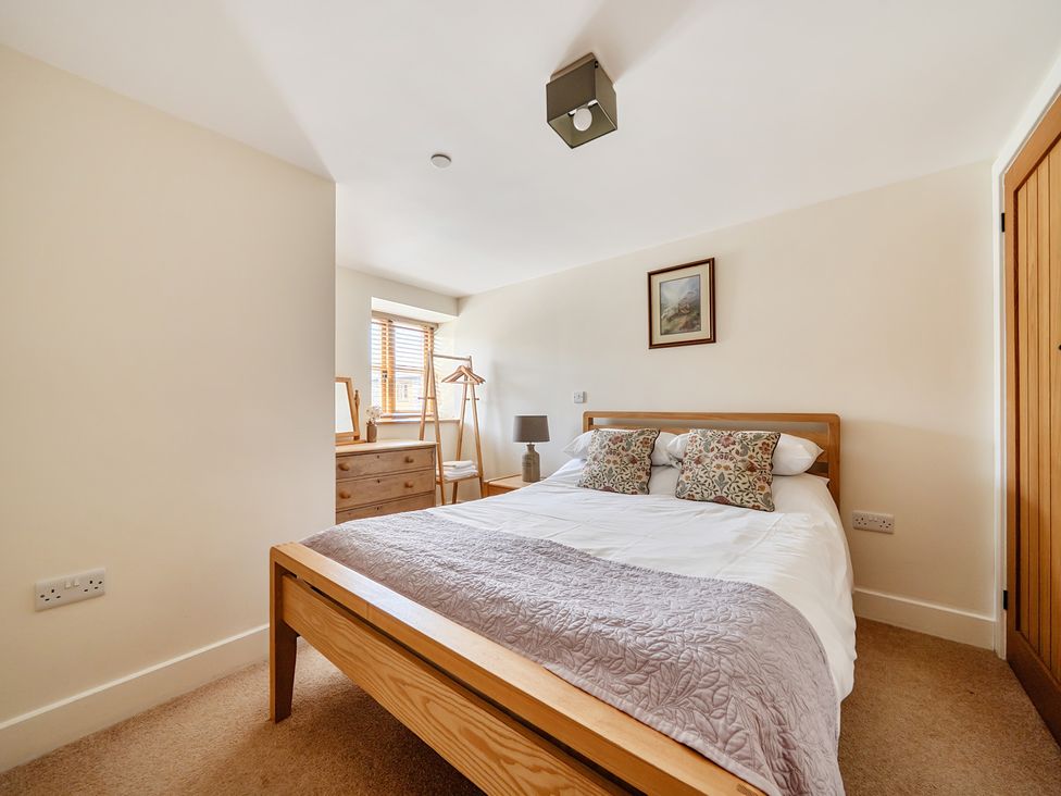 A bedroom with a bed and dresser at The Granary in Corwen