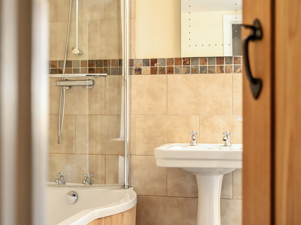A bathroom with a bathtub and sink at The Granary in Corwen