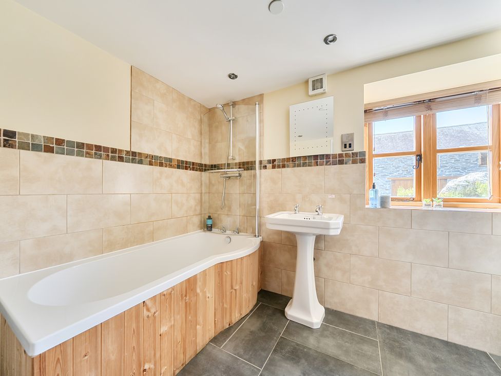 A bathroom with a bathtub and a sink at The Granary in Corwen