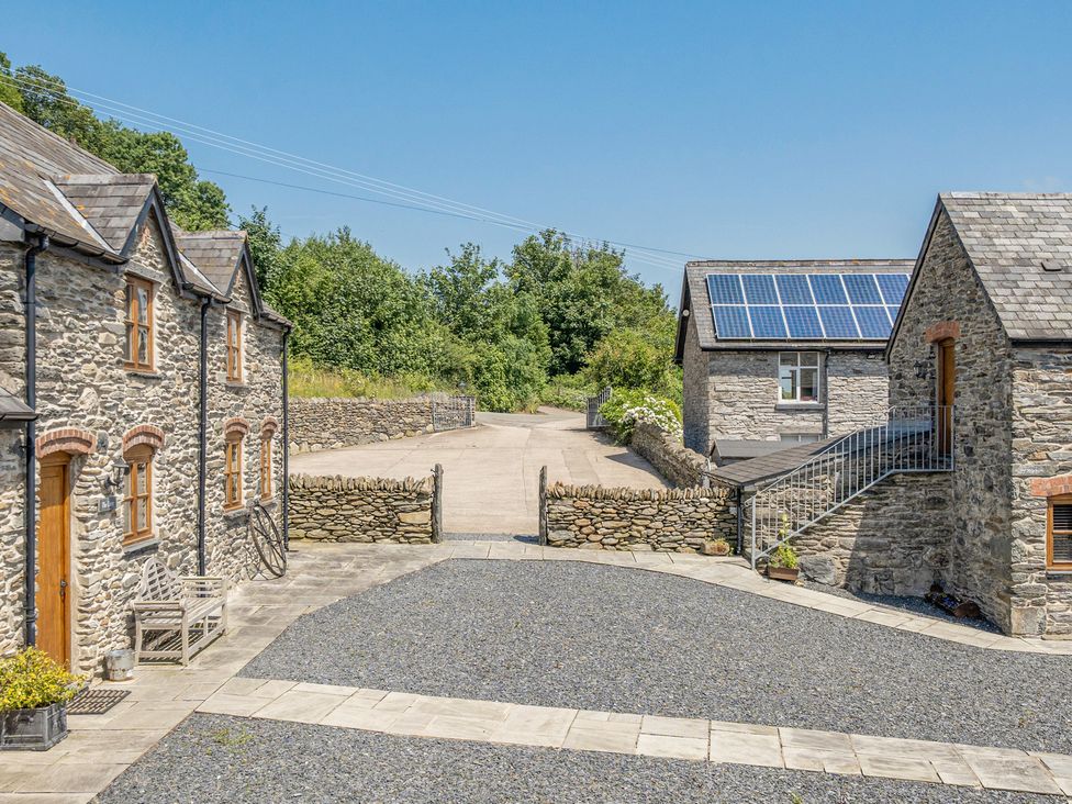 A view of stone houses and a gravel driveway at The Granary in Corwen