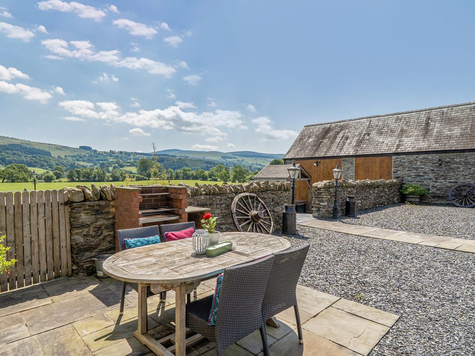 An outdoor seating area with a barbecue at The Granary in Corwen