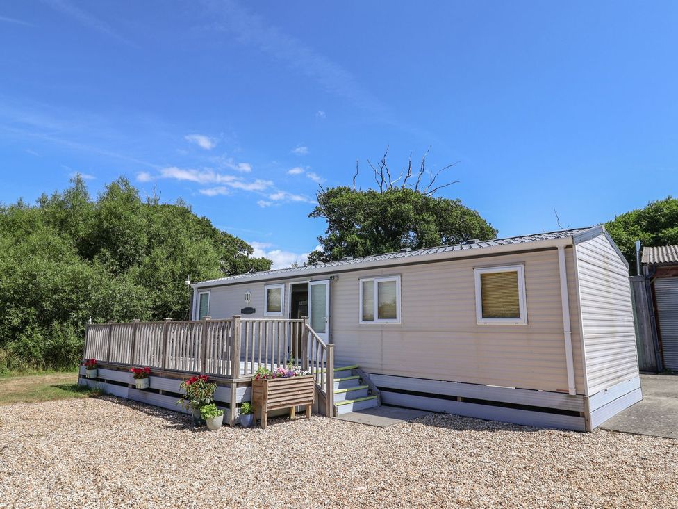 A mobile home with a deck and steps at The Hideaway in Portesham