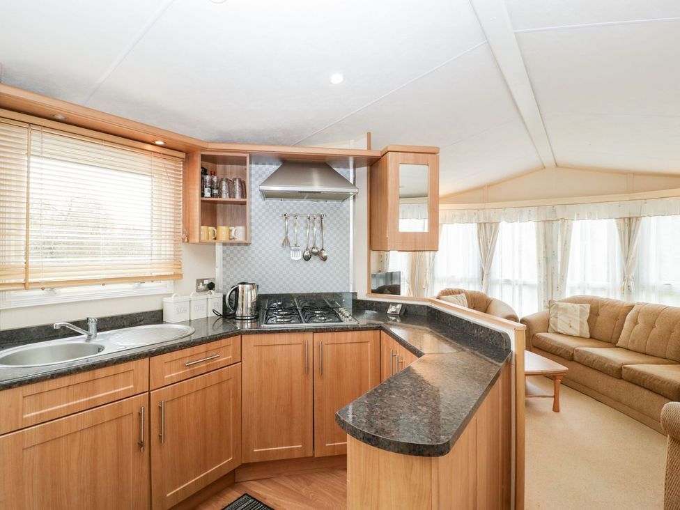 A kitchen with cabinets and appliances at The Hideaway in Portesham