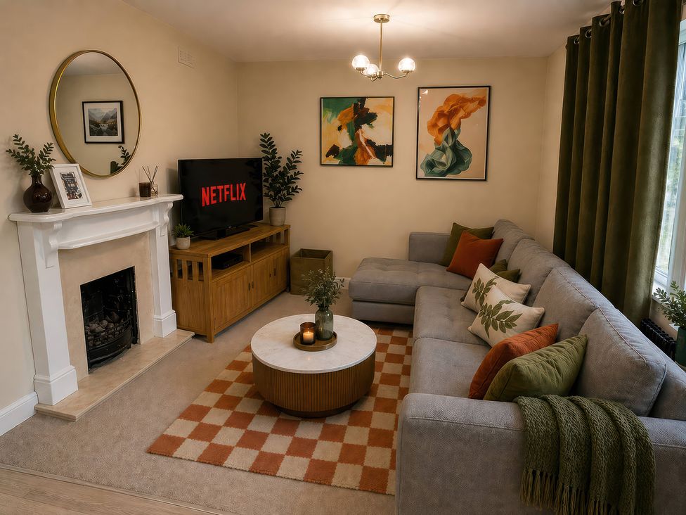 A living room with a sofa and a television at Haregate House in Leek