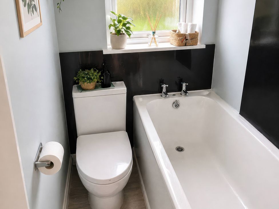 A bathroom with a bathtub and toilet at Haregate House Leek