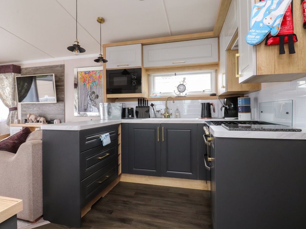 A kitchen with cabinets and cooking appliances at Marton Mere Westminster in Blackpool
