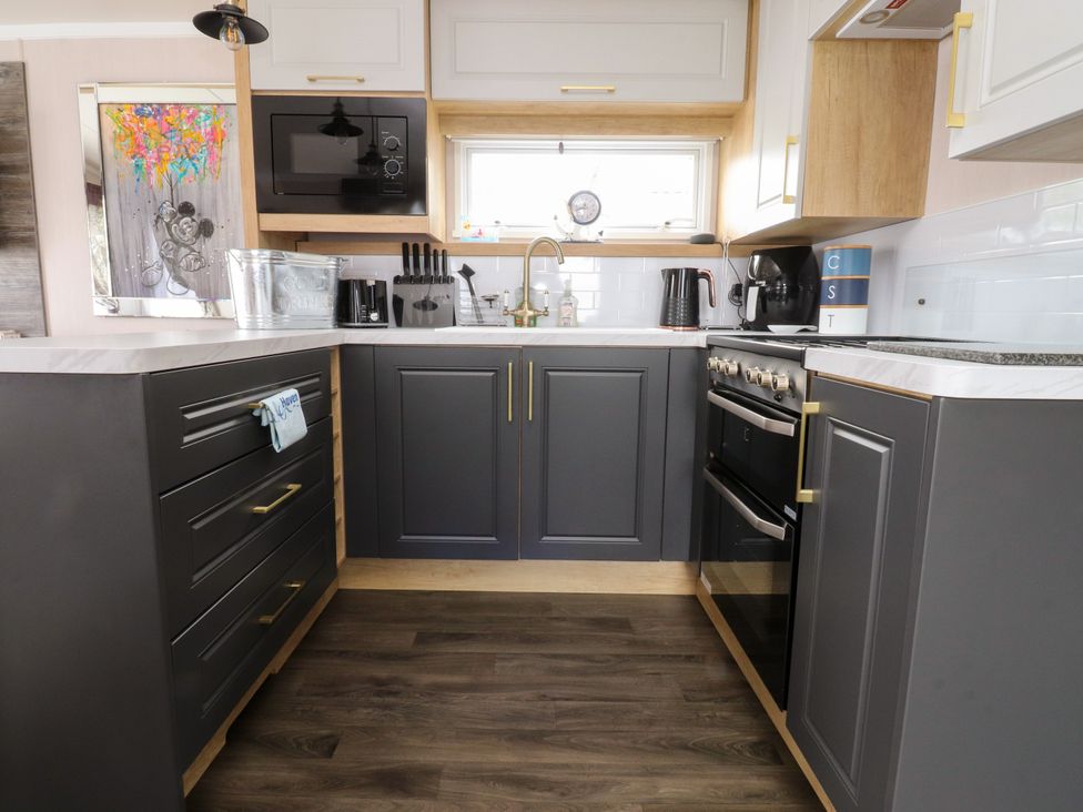 A kitchen with cabinets, sink, stove, and appliances at Marton Mere Westminster in Blackpool