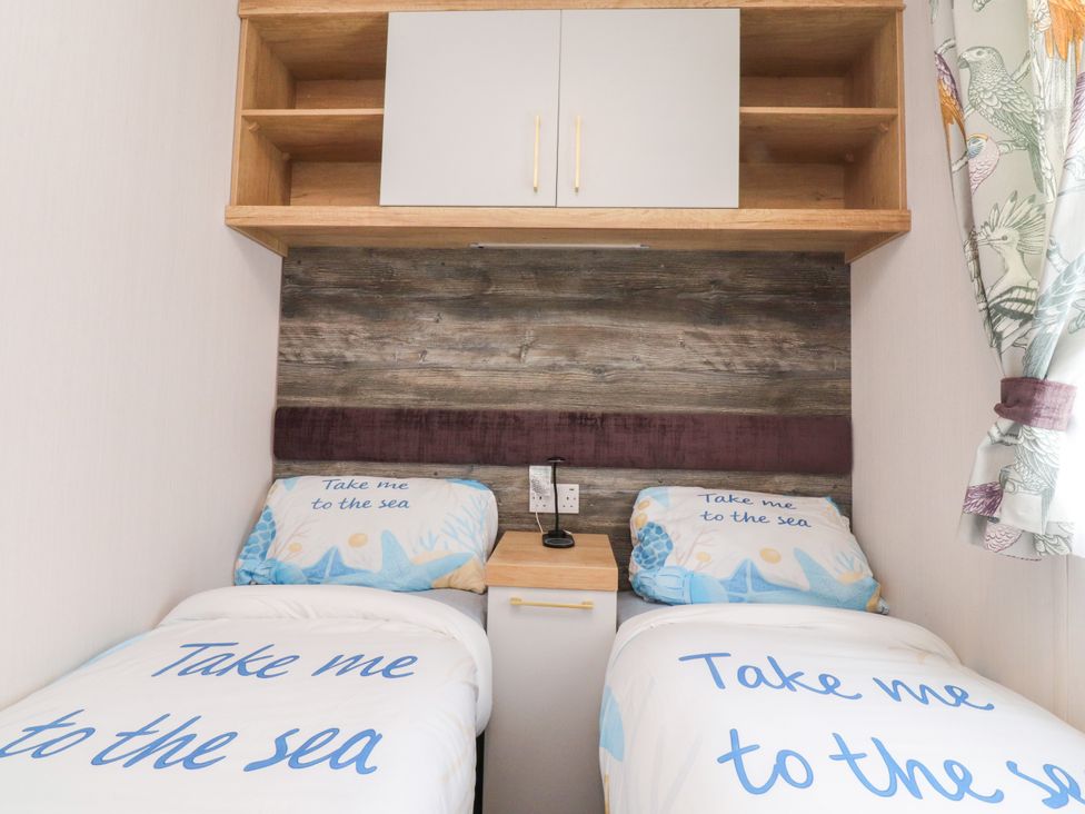 A bedroom with two beds and a shelf at Marton Mere Westminster Blackpool