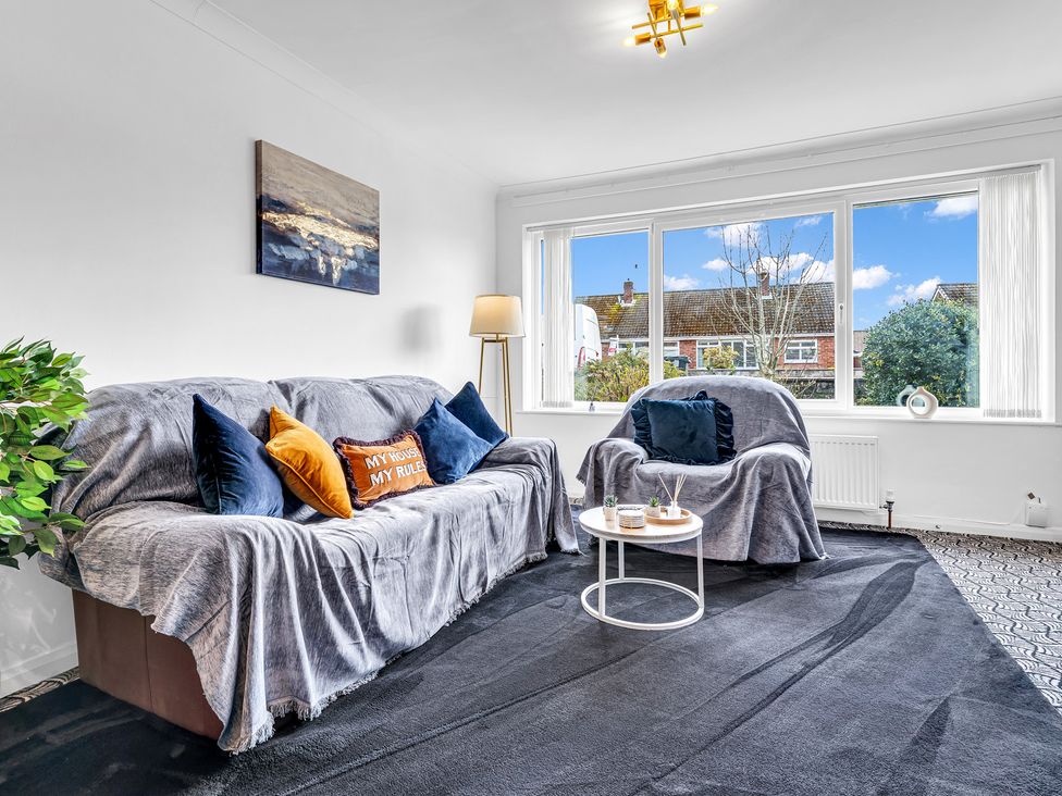 A living room with a sofa and armchair at Mallory House in Stoke-on-Trent