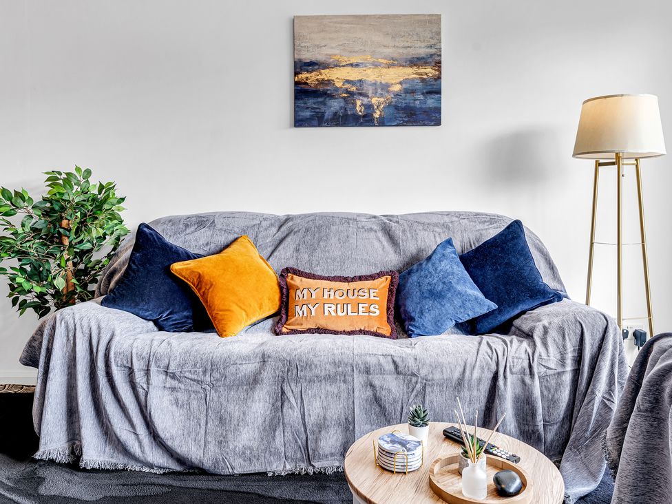 A living room with a sofa and cushions at Mallory House in Stoke-on-Trent