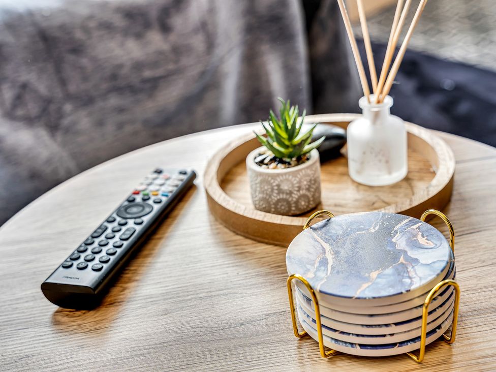 A coffee table with a remote control and decorative items at Mallory House in Stoke-on-Trent