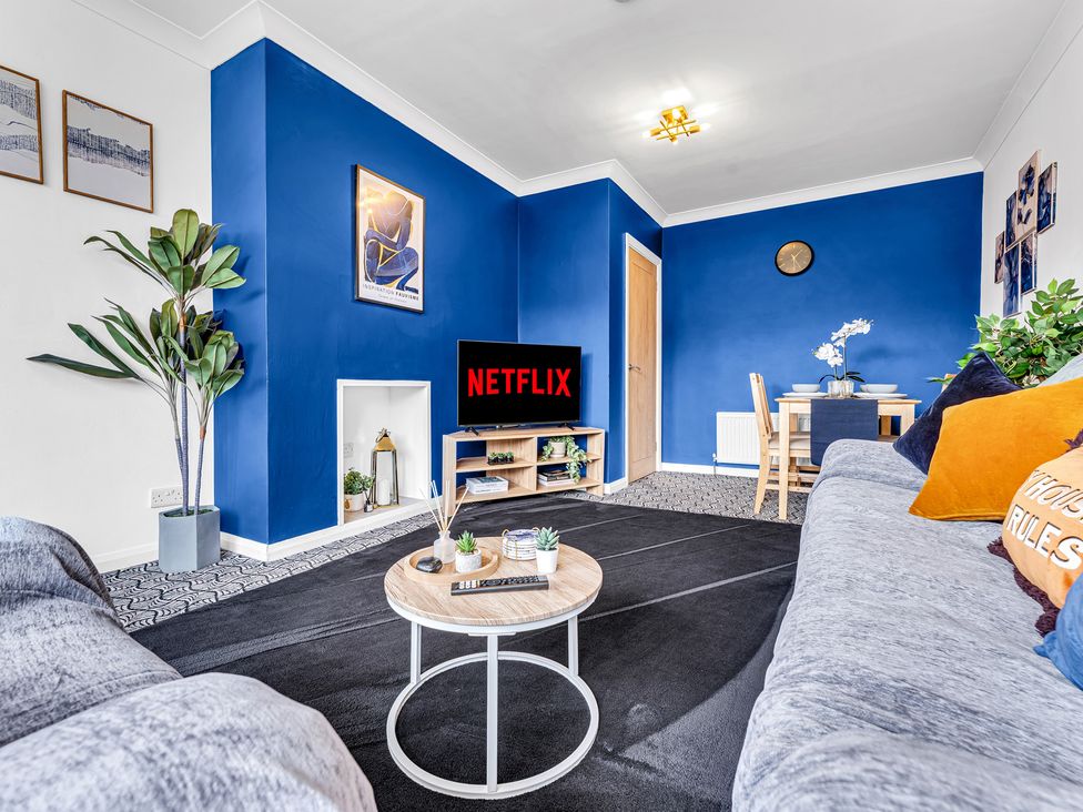 A living room with a sofa and television at Mallory House in Stoke-on-Trent