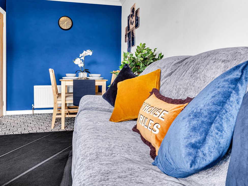 A living room with a sofa and a dining table at Mallory House Stoke-on-Trent
