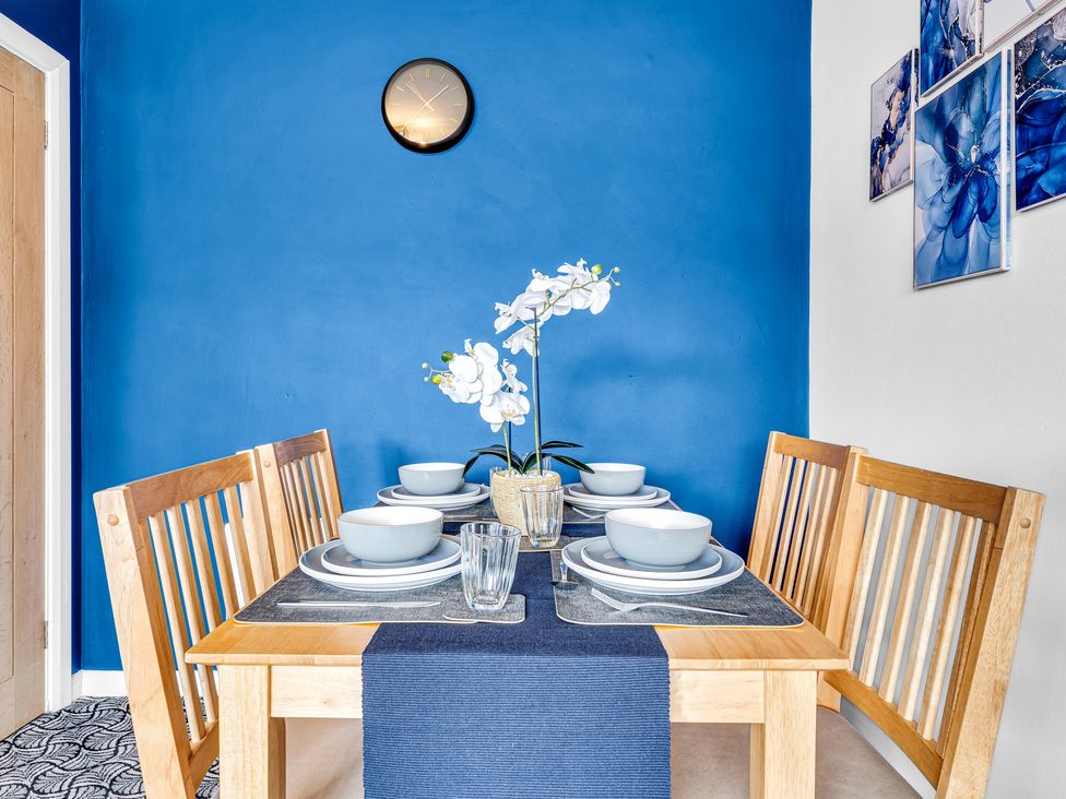 A dining room with a table set for meals at Mallory House in Stoke-on-Trent