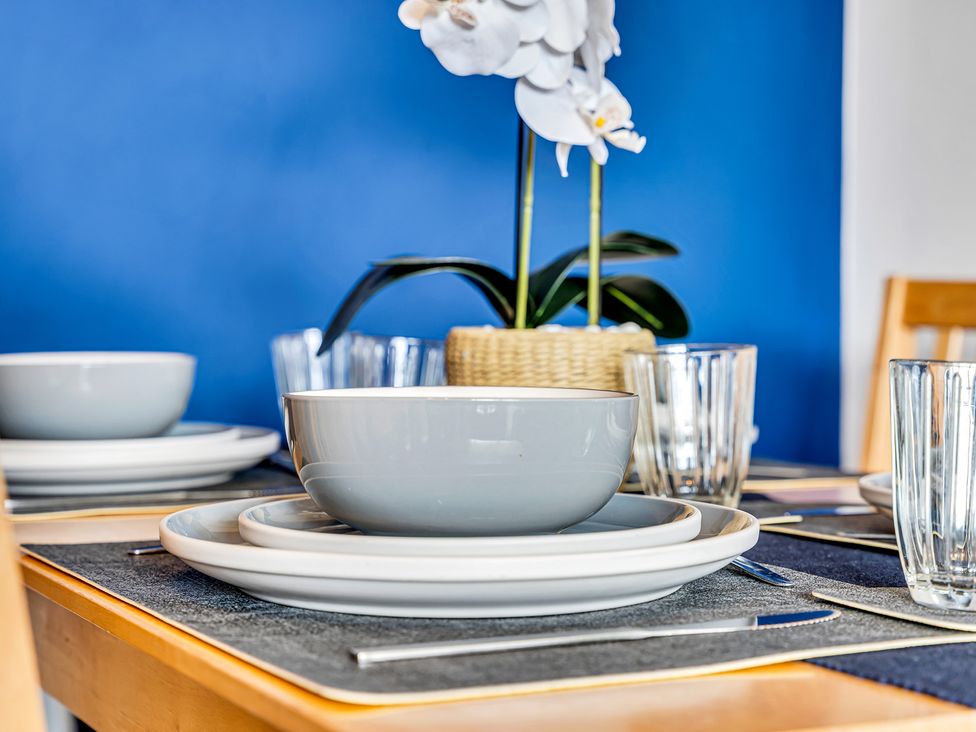 A dining table set with plates and glasses at Mallory House in Stoke-on-Trent